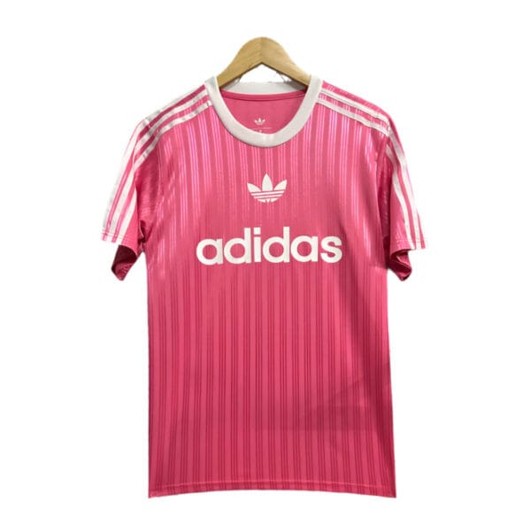 Pink Adidas football shirt with white logo and stripes.