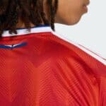 Close-up of Chile national football team home jersey 2025/26, red with geometric patterns.