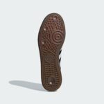 Bottom view of a brown rubber shoe sole with intricate tread patterns, set against a light gray background.