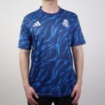 Authentic Real Madrid blue football jersey with dynamic wave pattern and team logo.