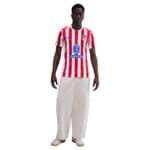 Atlético Madrid player home jersey 2025/26 with red and white stripes and club logo.