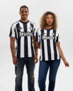 Newcastle United 2025/26 home football jersey with black and white stripes, official club logo, and.