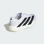 White Adidas running shoe angled to the side, showing the black three-stripe design against a pale gray background.