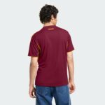Back view of a person wearing a maroon AS Roma sports jersey with orange trim, standing against a light background