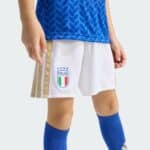 Close-up of a youth athlete's midsection wearing a blue patterned jersey, white shorts with gold trim and an ITALIA crest, and blue socks