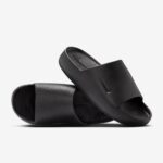 Black slide sandals with a single wide strap and textured footbed on a white background.