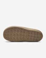 Brown sneaker sole with circular grip studs and concentric tread patterns laid horizontally across the bottom.