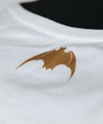 Dragon logo on white sports jersey, close-up view.