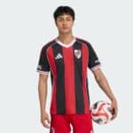 River Plate away football jersey 2025/26 with red and black stripes, official club logo, and Adidas.