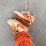 VaporWaffle sneakers featuring vibrant orange, pink, and white colors, perfect for sports and casual.