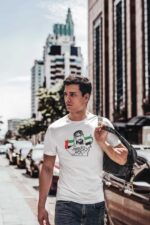 Man wearing UAE National Day 50th anniversary cotton T-shirt in city street.