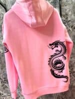 Pink hoodie with bold black dragon print on the back for a stylish look.
