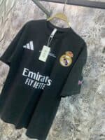 Authentic black Real Madrid football jersey with Emirates sponsor, Adidas logo, and club crest, perf.