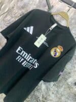 Authentic black Real Madrid jersey featuring club crest and sponsor logo, perfect for soccer fans an.