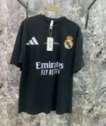 Real Madrid black football jersey with sponsor logo and club crest, authentic sportswear for fans.
