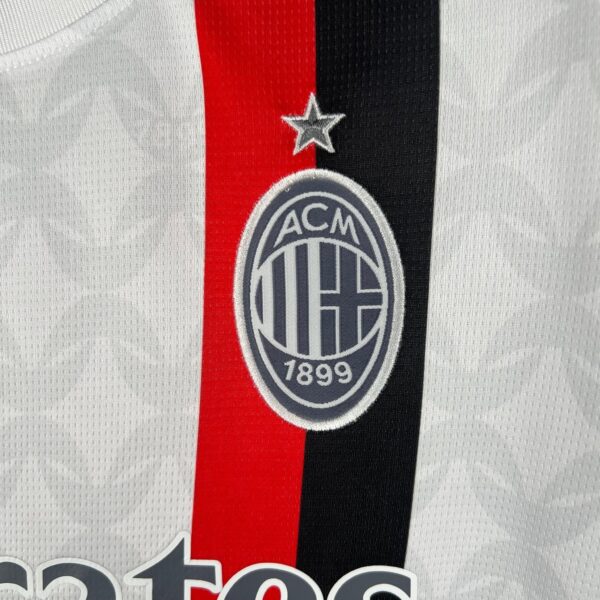 AC Milan logo on football jersey with red and black stripes.