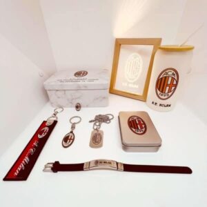 AC Milan branded accessories including keychains, lanyard, and tin box.