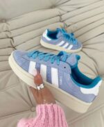 حذاء رياضي أديداس كامبوس Sky Blue 00s مع خطوط بيضاء وتصميم مريح.