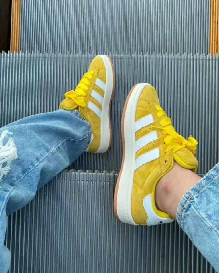 Adidas Campus 00s Spice Yellow sneakers with white stripes, yellow laces, and suede material.