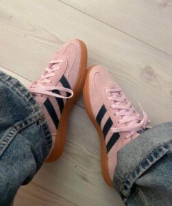 Pink Adidas Handball Spezial sneakers with black stripes and gum sole.