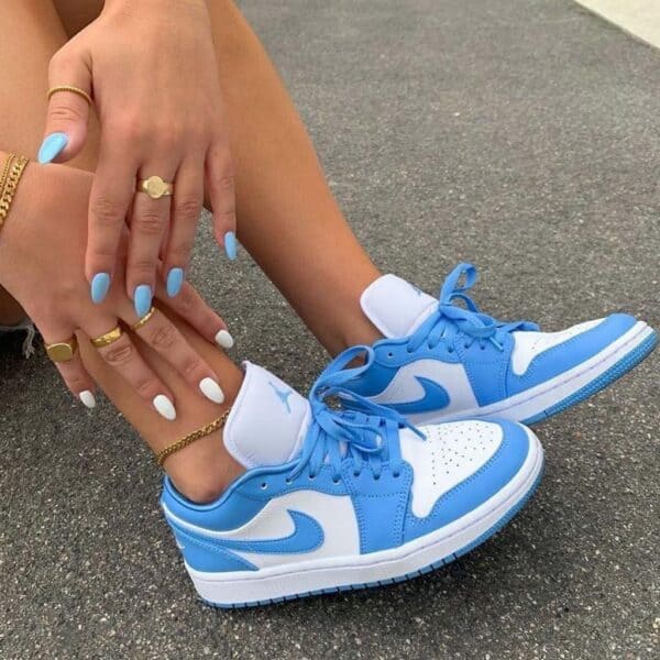 Air Jordan 1 Low "University Blue" sneakers with white and blue colorway. Perfect for casual and spo.