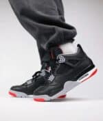 Air Jordan 4 Retro "Bred Reimagined" sneakers with black, red, and white design.