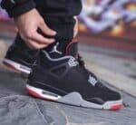 Air Jordan 4 Retro "Bred Reimagined" sneakers with black, red, and white design.