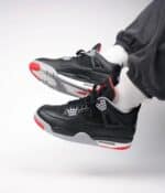 Air Jordan 4 Retro "Bred Reimagined" sneakers with black, red, and white design.