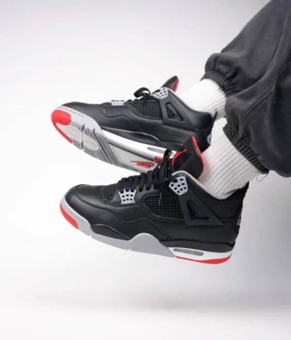 Air Jordan 4 Retro "Bred Reimagined" sneakers with black, red, and white design. Perfect for basketb.