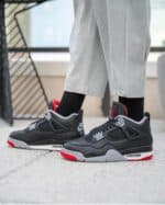 Air Jordan 4 Retro "Bred Reimagined" sneakers in black, red, and grey.