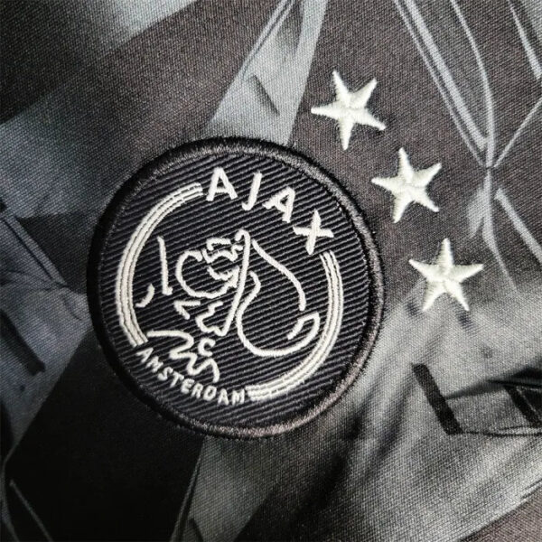 Close-up of AJX third kids football kit 2023/24 with logo and stars.
