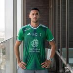 Al-Ahli Saudi home fans soccer jersey, green with team logos and sponsor, for passionate supporters.