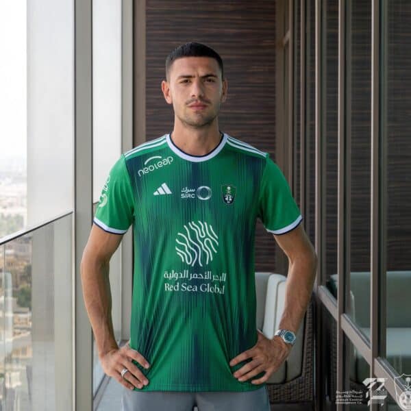 Al-Ahli Saudi home fans soccer jersey, green with team logos and sponsor, for passionate supporters.