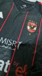 Kids Al Ahly away football jersey 2023/24 with team crest and red stripe details.