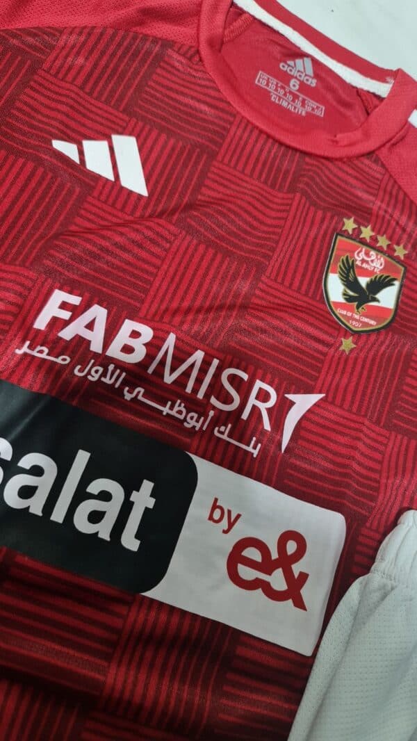 Red Al Ahly kids' football jersey with club crest and sponsor logos, 2023/24 season.