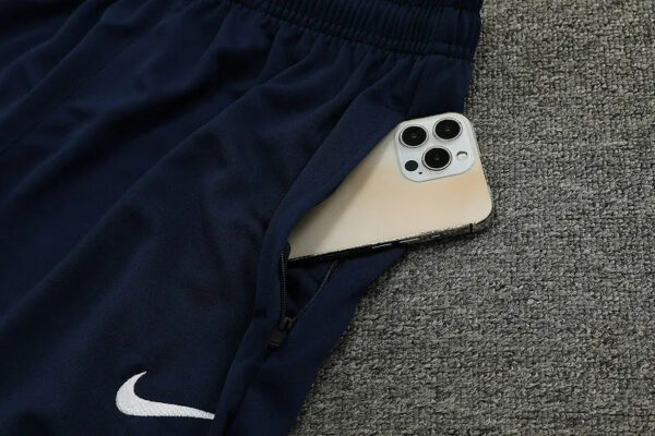 High-quality Nike blue tracksuit with a smartphone in the pocket, ideal for football training and sp.