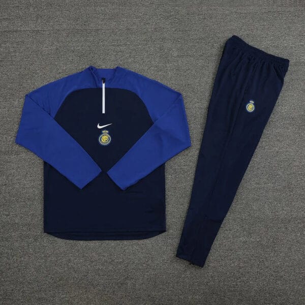 Al Nassr blue tracksuit 2023/24 with team logo, perfect for fans and athletes.