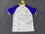 Training jersey with blue, yellow, and white design for AL Nassr 2023/24 season.