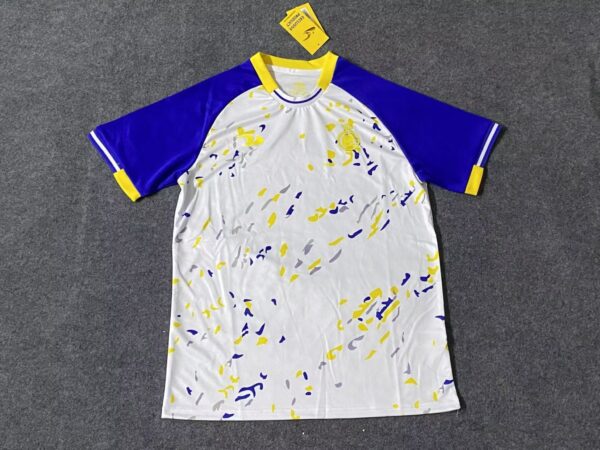 Training jersey with blue, yellow, and white design for AL Nassr 2023/24 season.