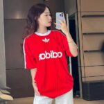 Red adidas Adicolor T-shirt with white logo and stripes.