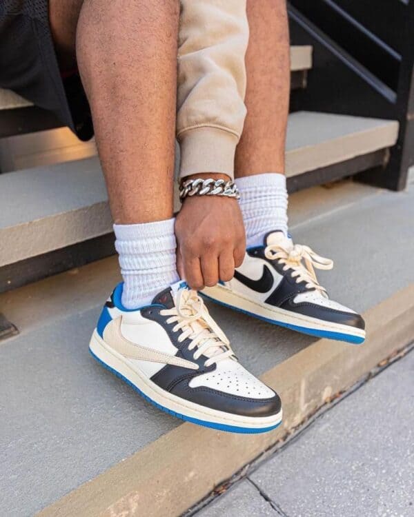 Travis Scott x Fragment x Air Jordan 1 Low sneakers on a person's feet.