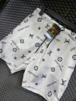 Louis Vuitton monogram white swim shorts with LV logo print, perfect for beach or poolside wear.