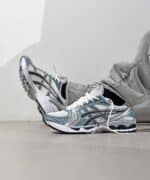 ASICS Gel-Kayano 14 running shoes in white, fjord grey, and black, designed for comfort and support.