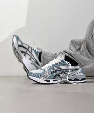ASICS Gel-Kayano 14 running shoes in white, fjord grey, and black, designed for comfort and support.