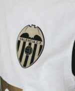 Valencia C.F. team logo embroidered on white football jersey.