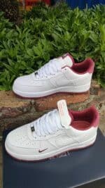 Air Force Low 1 sneakers in white with red accents, stylish and comfortable.