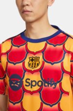 Pre-Match football jersey with Barcelona crest and Spotify logo, vibrant red and yellow design.