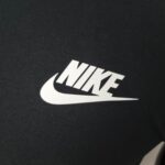 Close-up of Nike logo on black and white sports shirt, two-tone design.