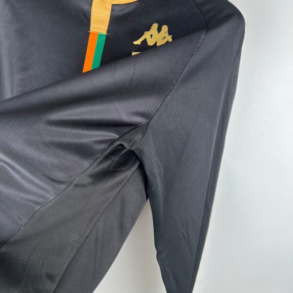 Black Kappa football track pants with logo and colorful stripe detail.