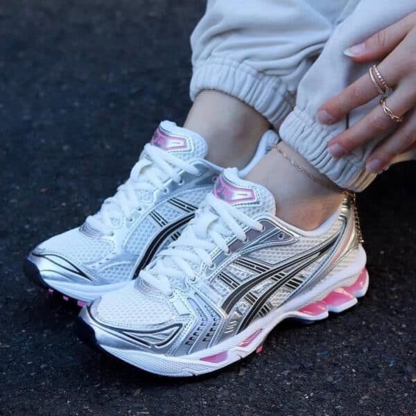 Athletic ASICS GEL-Kayano 14 sneakers in cream and pink for women.
